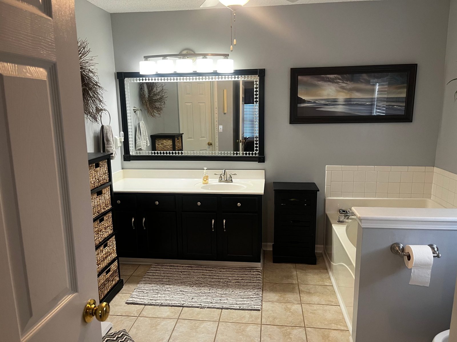 Bathroom with clean vanity, mirror and tub